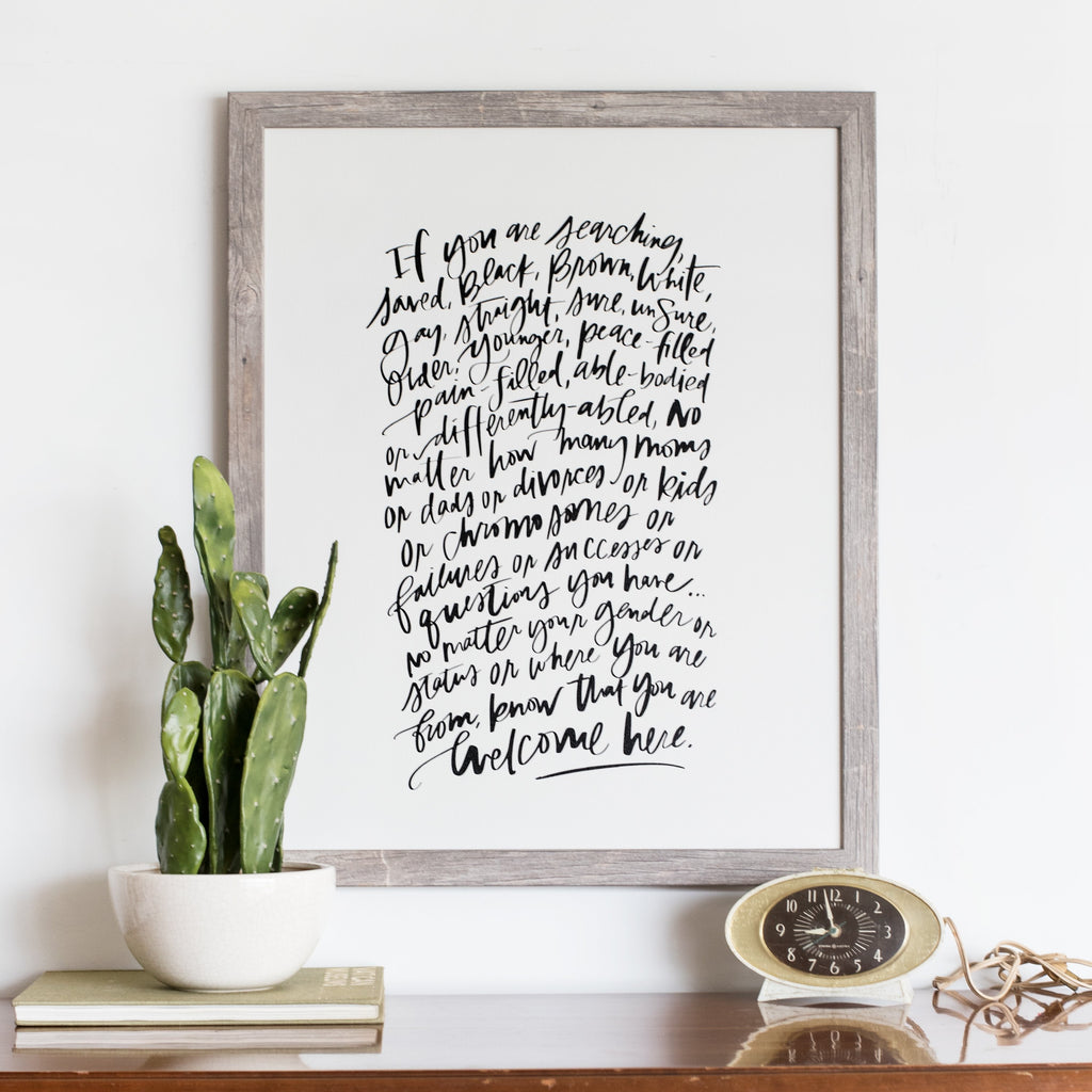 styled inspiration photo of welcome here manifesto calligraphy artwork in white
